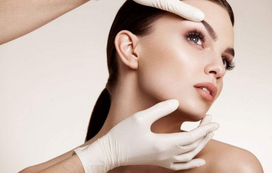 the cosmetologist examines the facial skin before rejuvenation